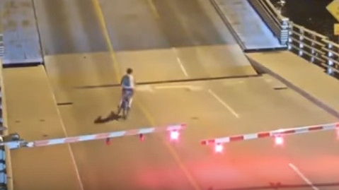 Complètement inconsciente, cette cycliste s'engage sur un pont basculant en action (vidéo)