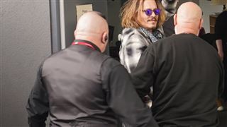Johnny Depp escorté hors d'un hôtel, une tasse à café dans la main (photos)